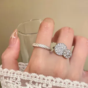 Close-up of elegant silver-tone rings featuring zircon star disc and twisted design