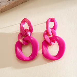 Close-up of hot pink acrylic chunky chain earrings with a glossy geometric finish