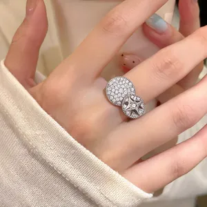 Detailed view of an elegant silver open ring with star and pavé zircon discs on a finger