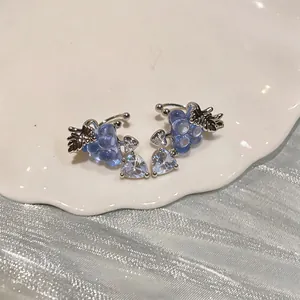 Detailed macro view of grape-shaped ear clips with heart-shaped zircon charms