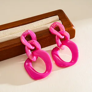 Detailed view of bright pink acrylic chain link earrings with geometric design
