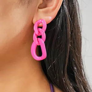 Vibrant pink acrylic chain link drop earrings shown worn on ear for detail view