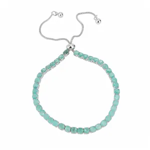Bracelet bolo réglable en argent avec des zircons ronds vert menthe sur un fond blanc épuré