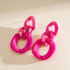 Macro view of vibrant pink acrylic chain link geometric earrings with dopamine style aesthetic