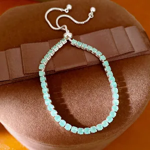 Gros plan d'un élégant bracelet ajustable en zircon vert menthe sur écrin marron