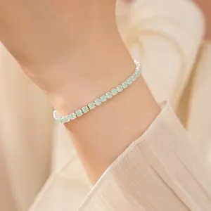 Gros plan d'un bracelet en argent avec des pierres de zircon vert clair au poignet