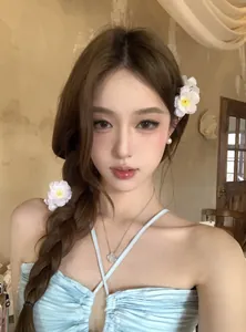 Détail de pinces à cheveux en fleurs de tissu blanc portées par un mannequin asiatique