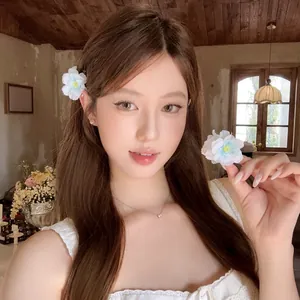 Gros plan d'une pince à cheveux en fleur de tissu douce pour un style de vacances.