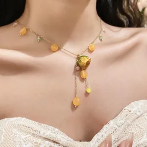 Detailed view of a handmade yellow eternal rose necklace with resin beads and gold chain