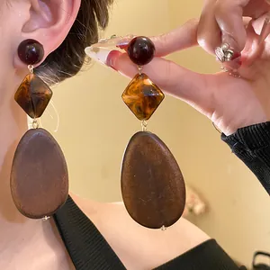 Detailed view of vintage Maillard wooden oval dangle earrings with tortoise resin accent