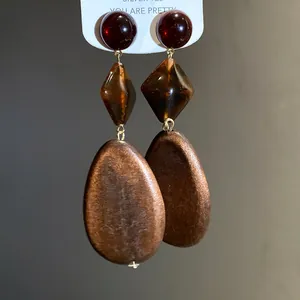 Close-up detail of retro Maillard style earrings with brown wood and resin beads
