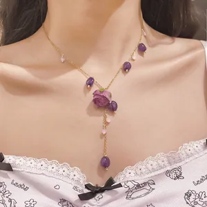 Detailed view of handmade purple resin rose flower tassel necklace on gold stainless steel chain