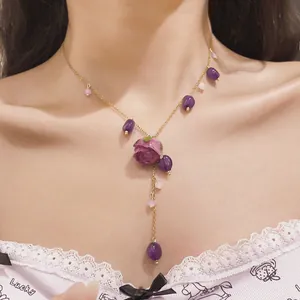 Detailed view of the purple resin eternal rose pendant with tassel on a gold chain