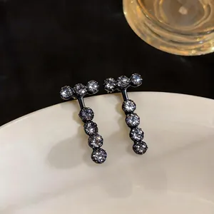 Detailed view of elegant black geometric stud earrings set with round clear zircons
