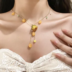 Close-up of elegant resin preserved flower necklace with tassels on golden chain