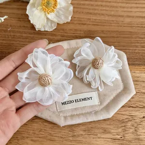 Exquisite white sheer fabric flower stud earrings with woven raffia centers and silver needles