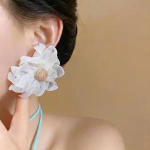 Exaggerated white mesh flower earrings with raffia center for summer resort style.
