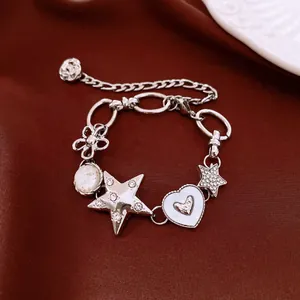 Gros plan d'un bracelet punk argenté orné de breloques en forme d'étoile et de cœur