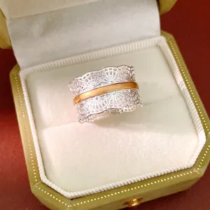 Elegante anello filigrana d'argento a pizzo cavo con fascia dorata in una scatola