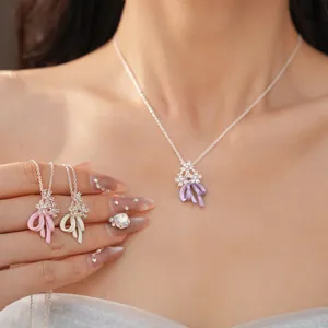 Dettaglio della collana con fiori di zircone e fiocchi smaltati in dolci colori pastello