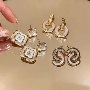 Vista detallada de elegantes pendientes bañados en oro con nácar y circonitas