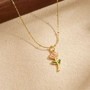 Detailaufnahme eines vergoldeten Rosenanhängers mit rosa Emaille-Blüten.