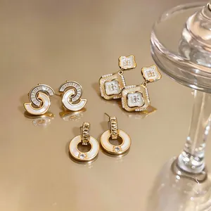 Vista detallada de pendientes de oro estilo francés con nacre y detalles de circonita
