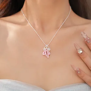 Primo piano di una collana d'argento con fiori di zircone e fiocco rosa su una modella