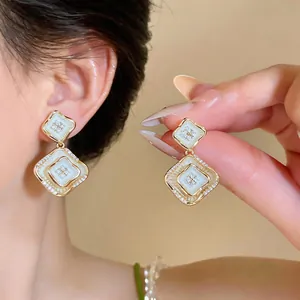 Vista detallada de elegantes pendientes estilo francés con nácar y circonitas