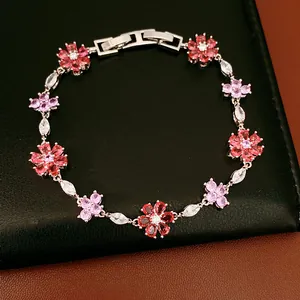 Close-up of vintage bracelet featuring pink and red zircon flower charms