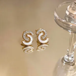 Primer plano detallado de pendientes de oro con nácar y circonitas baguette muy elegantes.