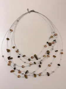 Dettaglio della collana multistrato in filo metallico con perle occhio di tigre.