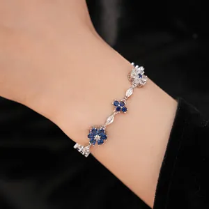 Detailed macro view of vintage flower and cross bracelet with blue zircons on a wrist