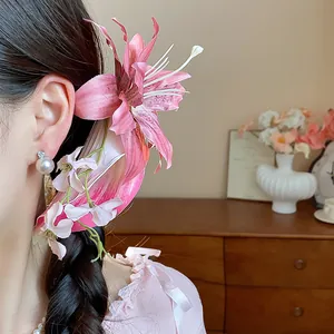 Close-up of a model wearing a sweet pink fabric lily hair clip with pearl accents.