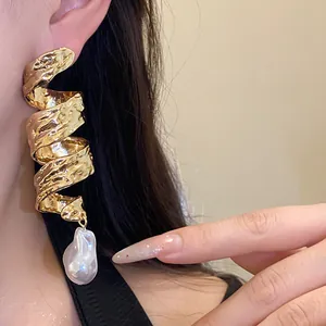 Detailed view of vintage golden twisted spiral earrings featuring a large baroque pearl drop
