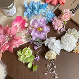 Detailed view of various colorful fabric flower hair clips featuring elegant pearl tassels