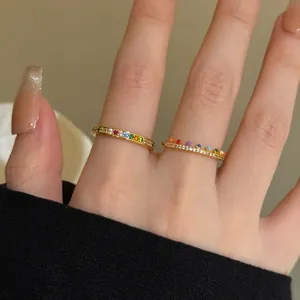 Close-up detail of ultra-thin gold stacking rings with rainbow zircon stones