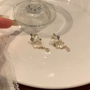 Close-up of elegant French style flower earrings with sparkling zircon tassels