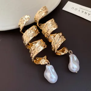 Detailed close-up view of vintage gold twisted spiral earrings with baroque pearl drops