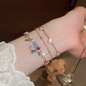 Vista detallada de pulseras chapadas en oro de 18k con flores de circón y motivos trébol.