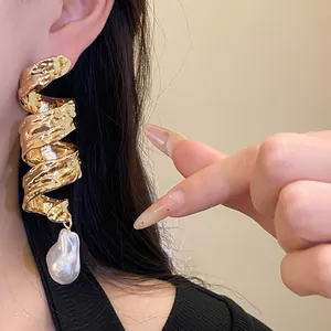 Detailed view of vintage gold twisted spiral earrings with a baroque pearl pendant.