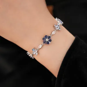 Close-up detail of a vintage silver-tone bracelet with blue and clear floral zircon stones.
