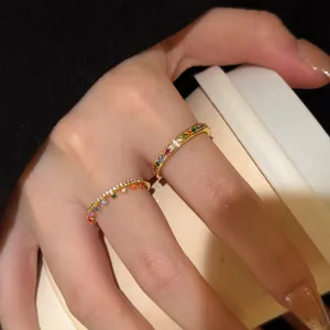 Detailed close-up of gold rainbow rings with colored zircon and enamel drop charms.