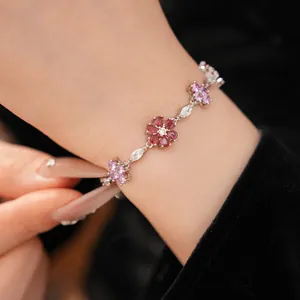 Detailed close-up of zircon flower bracelet with pink and red stones on wrist