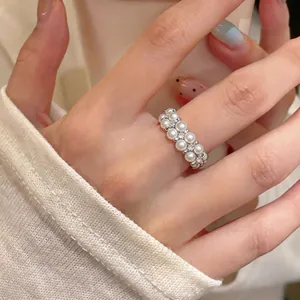 Elegant double-layered pearl ring with sparkling stones on silver-plated band.