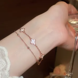 Primer plano de pulsera de trébol chapada en oro rosa con incrustación