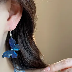 Elegant detailed view of a blue resin butterfly clip-on earring worn on a model's ear