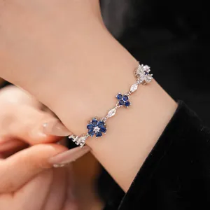 Close-up of exquisite zircon flower and cross charms on a vintage style bracelet.