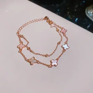 Detalle macro de pulsera de doble capa chapada en oro de 18k con flores de nácar