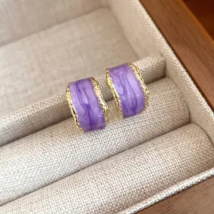 Orecchini vintage a forma di C con smalto viola e bordi dorati martellati.